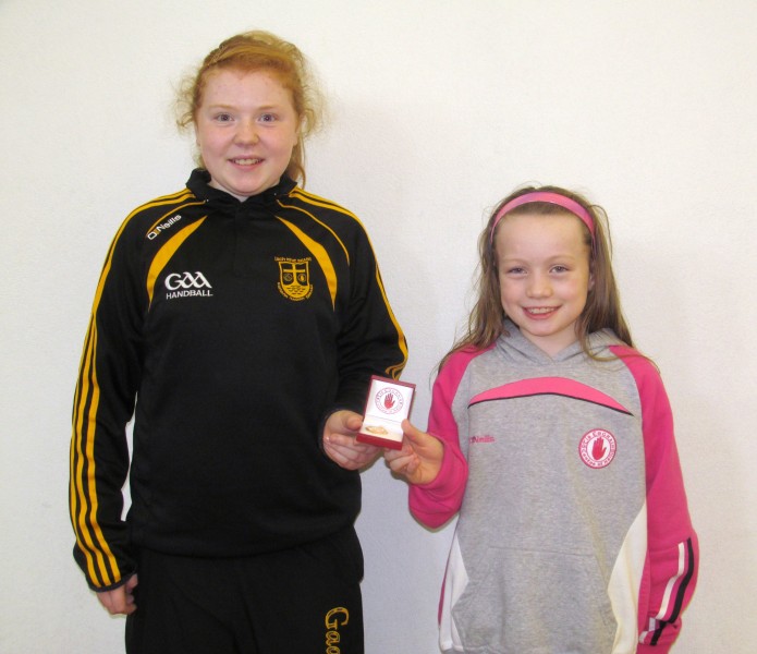 U12 girls winner Caitlin Conway receives her medal from Maeve McCrystal representing county sponsor Tyrone Attic Stairs